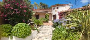 ogród z różowymi kwiatami i dom w obiekcie Villa La Louvière La Croix Valmer Golfe de Saint Tropez w mieście La Croix-Valmer