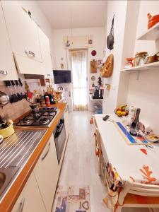 a kitchen with a stove and a counter top at WHOLE FLAT CLOSE BEACH BREAKFAST KITCHEN AIR CONDITIONING LAUNDRY SHUTTLE AIRPORT WI-FI CAR PARKING NETFLIX BALCONIES CHECK IN 24H & METRO to ROME in Lido di Ostia
