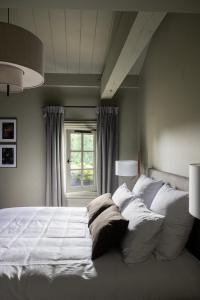 um quarto com uma grande cama branca e uma janela em Hotel Porte Brunet em Saint-Émilion