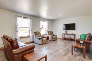 a living room with leather furniture and a flat screen tv at Wooded Hancock Home Near Ski and Snowmobile Trails! in Hancock