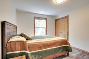 um quarto com uma cama e uma janela em Wooded Hancock Home Near Ski and Snowmobile Trails! em Hancock