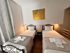2 Betten in einem Hotelzimmer mit Handtüchern darauf in der Unterkunft Pensao Nova Goa in Lissabon
