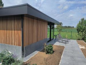 un bâtiment avec 2 bancs sur une terrasse dans l'établissement Mote26, à Ingooigem