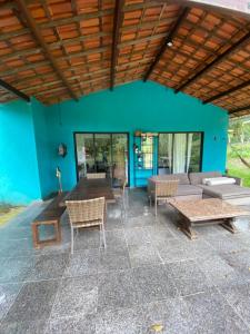 patio z kanapą, stołami i niebieską ścianą w obiekcie Casa Sabia w mieście Pacoti