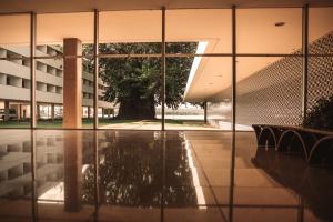 una vista exterior de un edificio con un árbol visto a través de las ventanas en Brasília Palace Hotel, en Brasilia