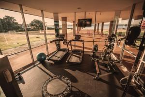 a gym with several treadmills and a television at Brasília Palace Hotel in Brasilia