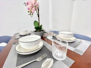 a table with plates and bowls and glasses on it at G4 1-8pax Sunway Medical Center Geo 3QBeds Wifi &TV in Kampong Penaga