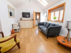 ein Wohnzimmer mit einem Sofa und einem TV in der Unterkunft Jasmine Cottage in Chester
