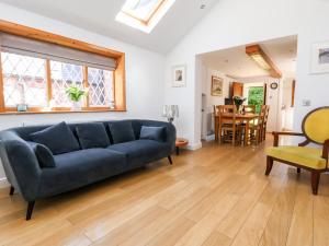 a living room with a blue couch and a table at Jasmine Cottage in Chester