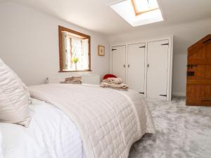 a white bedroom with a white bed with a window at Jasmine Cottage in Chester