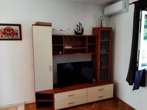 ein Entertainment-Center mit einem Flachbild-TV im Wohnzimmer in der Unterkunft Apartmani Šegedin in Korčula