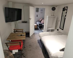 a small room with two beds and a television at Hidden Treasure-Netflix and Wi-Fi in Gillingham