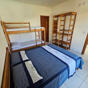 a bedroom with two bunk beds and two shelves at Vila Axé Flat 01 Riviera in Prado
