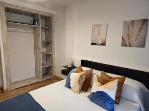 um quarto com uma cama com almofadas e uma janela em Apartamento El olivo em Empuriabrava