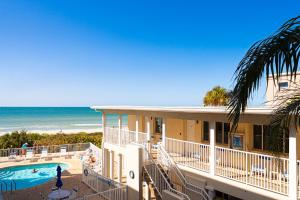 a building with a swimming pool and the beach at Emerald at Belleair Beach Club in Clearwater Beach