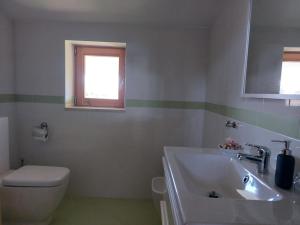 a bathroom with a sink and a toilet and a window at La Quercia in Altavilla Silentina