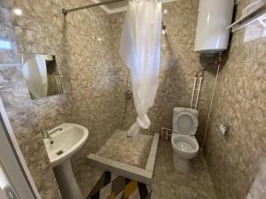 a bathroom with a toilet and a sink at Guest house "U apashki" in Tong