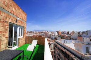 un balcone con panchina in cima a un edificio di Luminoso ático con vistas al mar a Almería