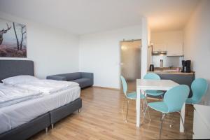 Un dormitorio con una cama y una mesa y sillas. en Welcome in - Apartments Am Waltenberg 57-59, en Winterberg
