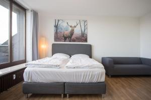 1 dormitorio con 1 cama con una foto de ciervo en la pared en Apartments Am Waltenberg 57-59 en Winterberg