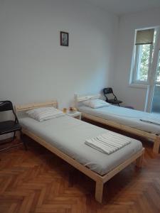 two twin beds in a room with a window at Стеди - стая за гости in Varna City