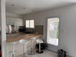 eine Küche mit einer Theke und Hockern darin in der Unterkunft 100 M DE LA PLAGE 100 DU BOURG DES MOUTIERS EN RETZ in Les Moutiers + 17 Fotos