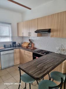 a kitchen with a wooden table and some chairs at 1 bedroom Morleen Park apartment in Swakopmund