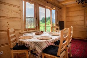 a dining room with a table with chairs and a window at Dom pod Smokami in Bukowina Tatrzańska