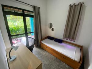 ein kleines Schlafzimmer mit einem Bett und einem Fenster in der Unterkunft Casa Sabia in Pacoti + 10 Fotos