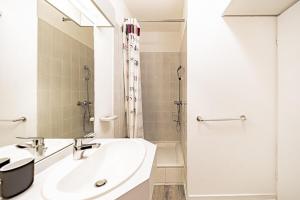 a white bathroom with a sink and a shower at Le petit Dauphiné-studio rénové-Sans soucis in Lyon