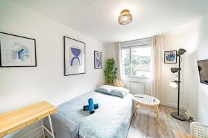 a bedroom with a bed and a desk and a window at Le petit Dauphiné-studio rénové-Sans soucis in Lyon