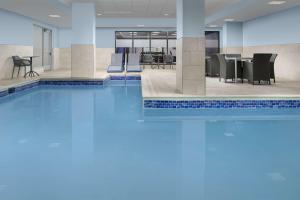 a swimming pool in a lobby with a table and chairs at Hampton Inn Baltimore-Downtown-Convention Center in Baltimore