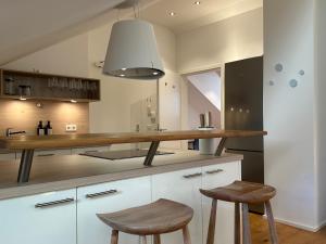 una cucina con bancone in legno e 2 sgabelli di Direkt am Rathausplatz, Dachterrasse mit Blick auf Perlachturm a Augusta (Augsburg)