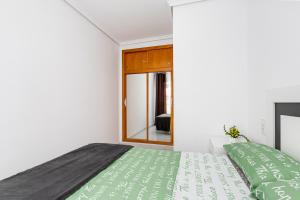 トレビエハにあるArquitecto Larramendiのベッドルーム1室(緑のシーツが敷かれたベッド1台、窓付)