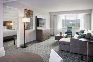 a hotel room with a bed and a living room at DoubleTree Birmingham Perimeter Park in Birmingham