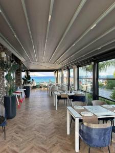Un restaurante con mesas y sillas y vista al mar. en İskelede denize sıfır havuzlu sitede Loft 1+1, en Boghaz