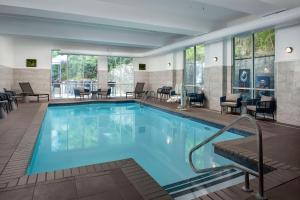 una piscina en una habitación de hotel con sillas y mesas en Doubletree by Hilton Chattanooga Hamilton Place en Chattanooga