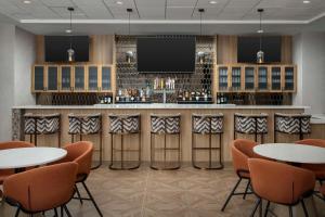 a bar with tables and chairs and a tv at Doubletree by Hilton Chattanooga Hamilton Place in Chattanooga