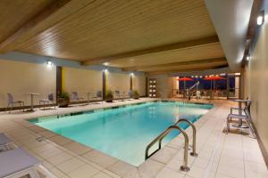 a large pool in a hotel with chairs and tables at Home2 Suites by Hilton Cincinnati Liberty Township in Wetherington