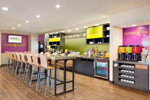 a restaurant with a bar with chairs and a counter at Home2 Suites by Hilton Cincinnati Liberty Township in Wetherington