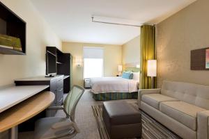 a hotel room with a bed and a living room at Home2 Suites by Hilton Cincinnati Liberty Township in Wetherington