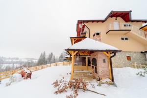 een huis met sneeuw op het dak bij Apartmani Šarović Tara 3 in Rača +6 foto's