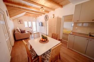 een keuken en woonkamer met een tafel en stoelen bij Apartmani Šarović Tara 3 in Rača