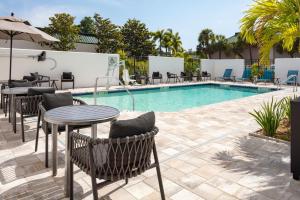 einen Pool mit Tischen und Stühlen neben einer Terrasse in der Unterkunft TownePlace Suites by Marriott Tampa Clearwater in Clearwater