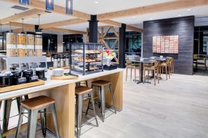 a restaurant with a counter with stools and tables at Hilton Garden Inn Jackson in Jackson