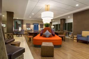 um átrio de escritório com uma cadeira laranja no meio em Home2 Suites by Hilton Phoenix Chandler em Chandler