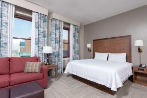 a bedroom with a bed and a red couch at Hampton Inn Indianapolis Downtown Across from Circle Centre in Indianapolis