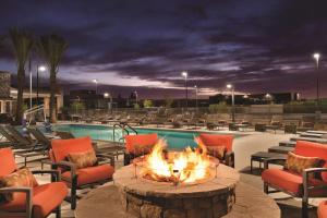 a fire pit in front of a pool with chairs at Home2 Suites By Hilton Phoenix-Tempe University Research Park in Tempe