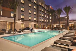 a hotel swimming pool with chairs and a hotel at Home2 Suites By Hilton Phoenix-Tempe University Research Park in Tempe