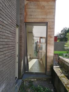 eine Glastür, die in ein Backsteingebäude führt in der Unterkunft A Namur même, rez avec terrasse in Namur